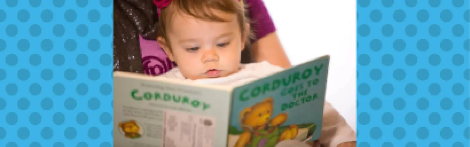 Baby reading a Dolly Parton's Imagination Library book